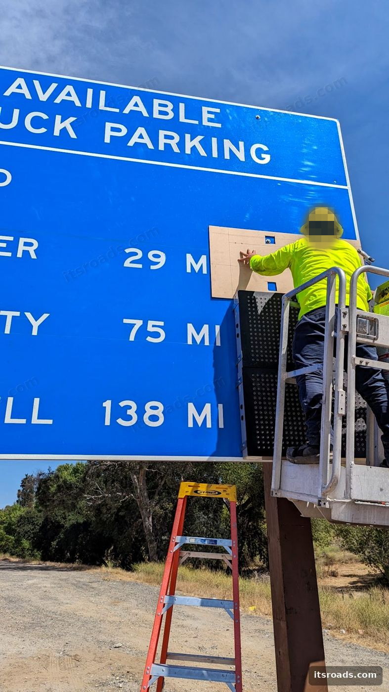 Technician in a bucket truck installing a Streetline TPAS availability sign